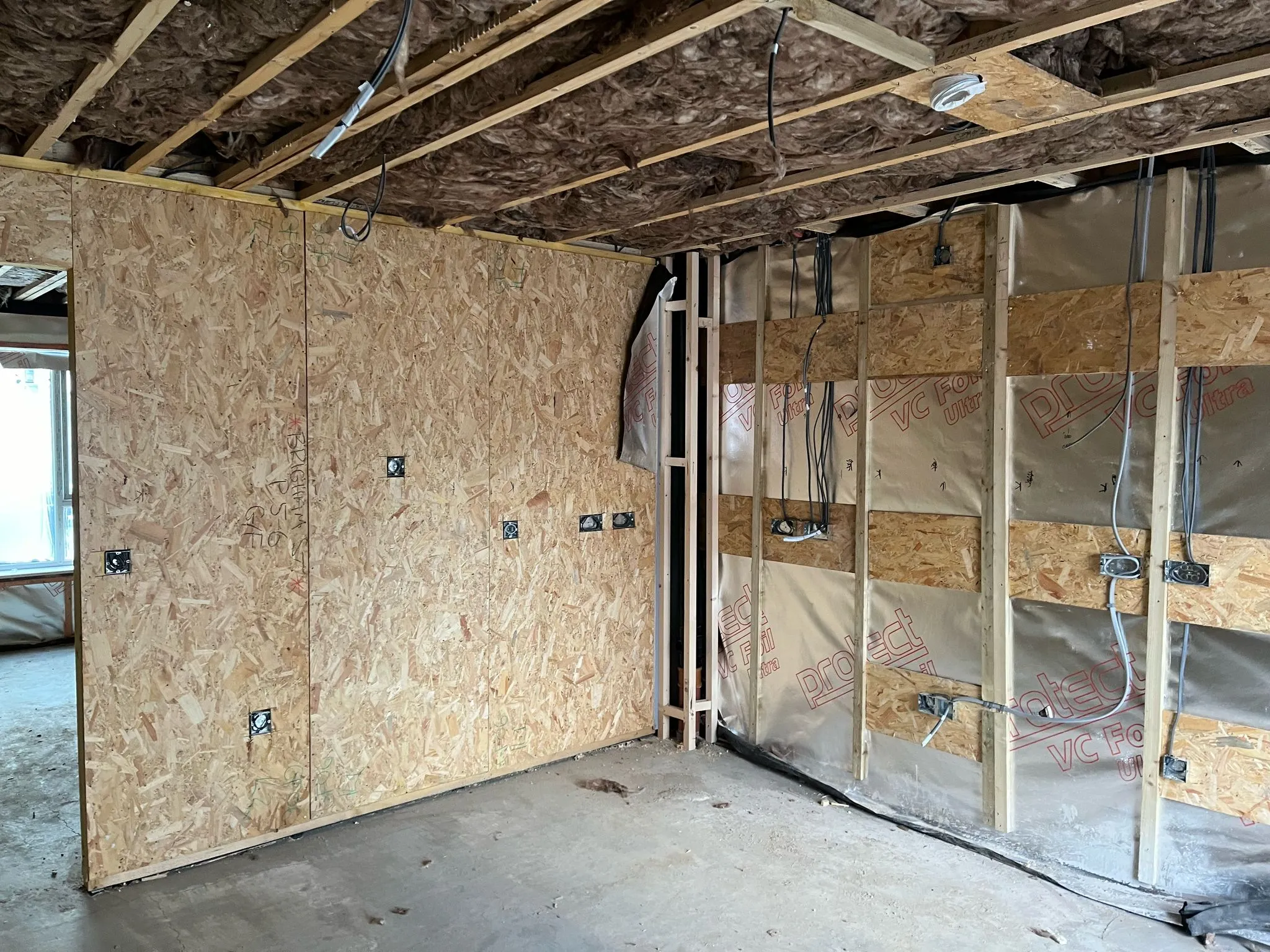 An unfinished room with a lot of plywood on the walls.